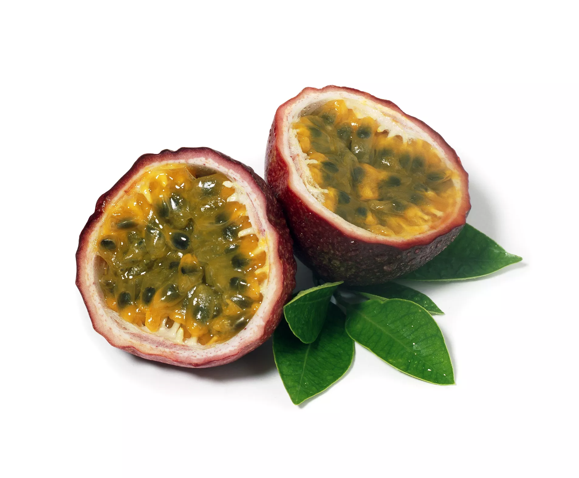 Passion fruit cut in half with leaves.